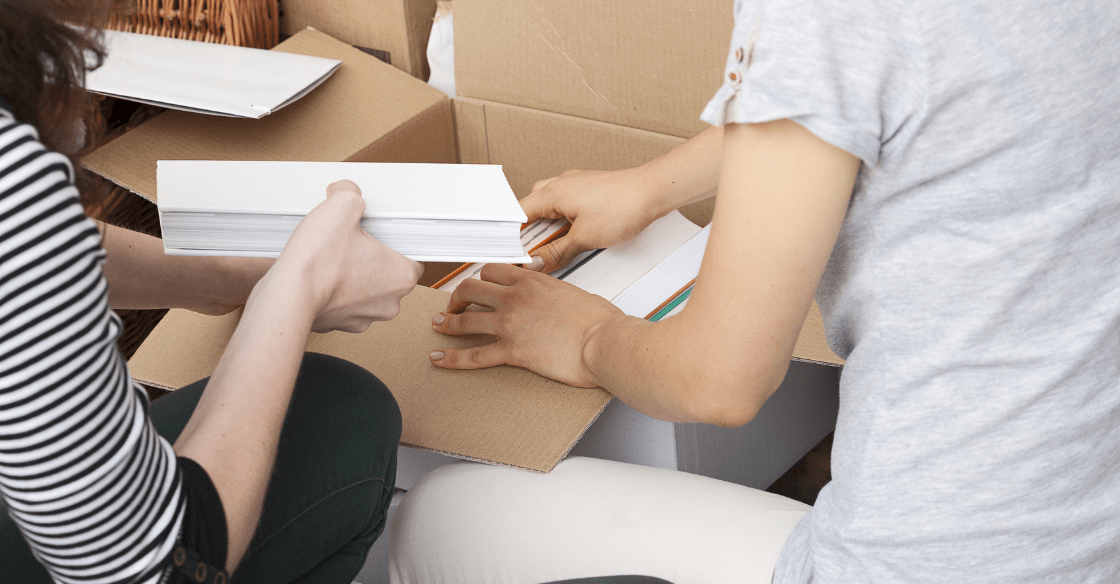 Packing books into a cardboard box