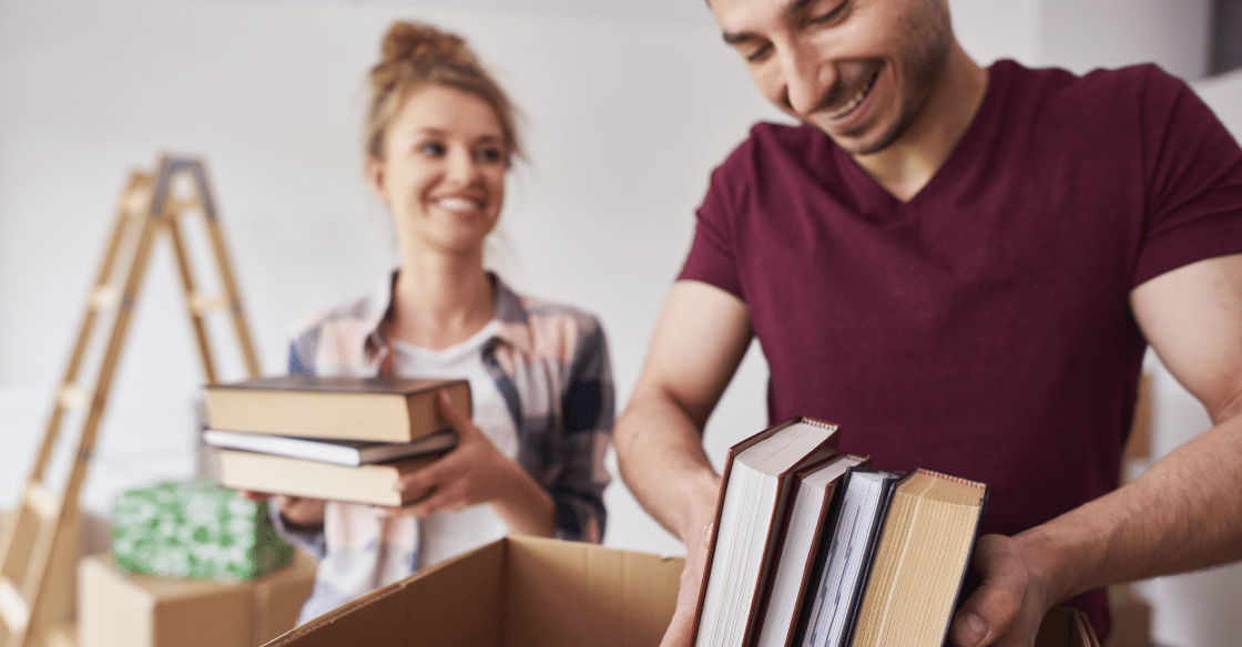Couple packing books for storage